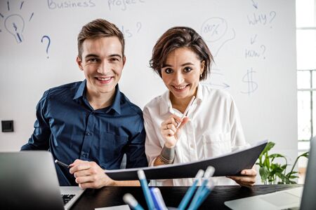 Smiling two coworkers discussing project in the officeの写真素材
