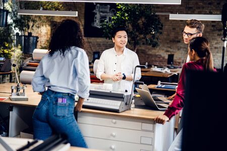 Handsome young man talking with colleagues at work