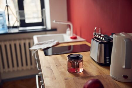 Teapot with tasty beverage on the drawers in apartmentの写真素材