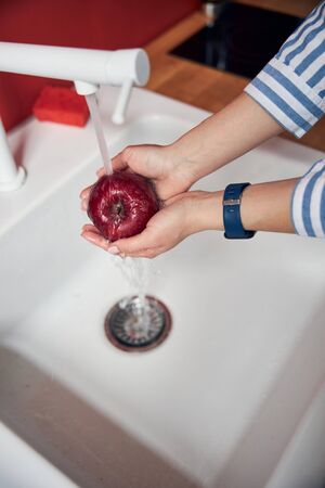 Young woman is washing appleの写真素材