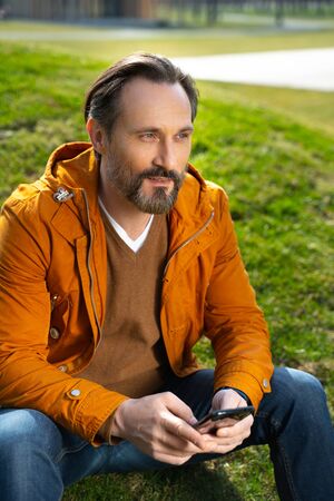 Handsome bearded man using smartphone on the street