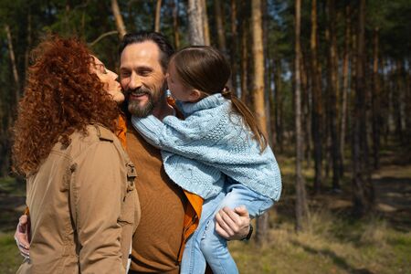 Happy loving family spending time together in forest