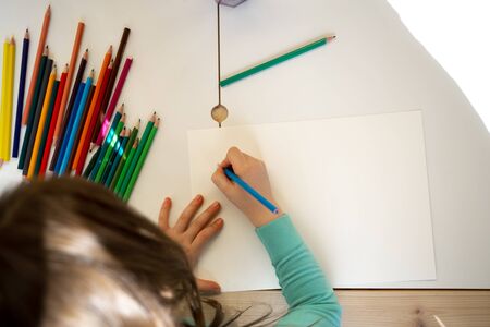 Child hand drawing on piece of paper