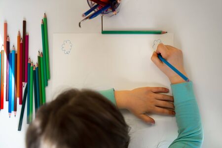 Little girl drawing on blank piece of paper