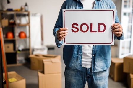 Cropped head of male standing in room with carton boxes and telling about selling it