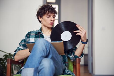 Handsome young man is holding gramophone recordの写真素材