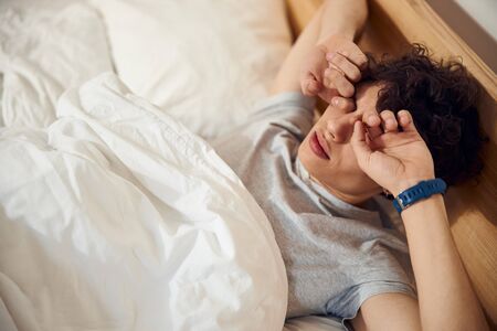 Handsome young man waking up early in the morningの写真素材