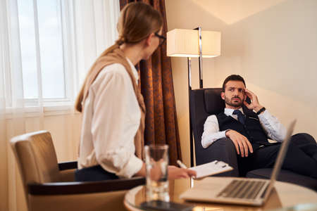 Man and woman discussing business project in hotel roomの写真素材