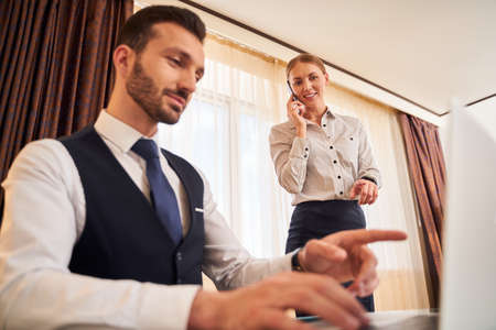 Young businesspeople working in hotel room during tripの写真素材