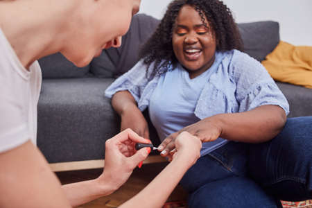 Charming positive lady enjoying manicure process at home