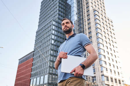 Serene young man with notebook in streetの写真素材
