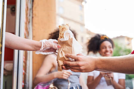 Male buying fast food in street stallの写真素材