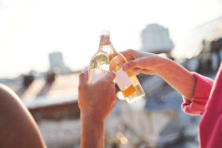 Two females celebrating with wine in open air