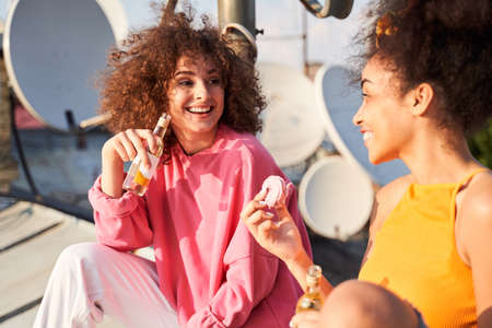 Cheerful females enjoying meeting on urban roofの写真素材
