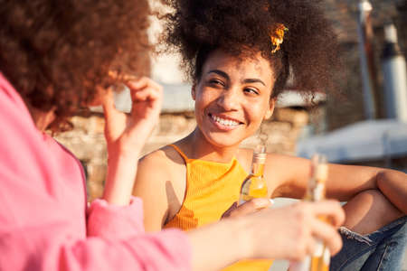 Happy young woman communicating with friend under sunの写真素材