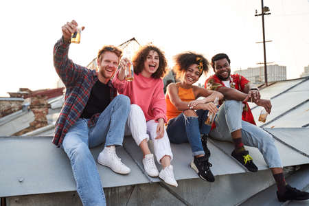Happy four people celebrating on urban roof