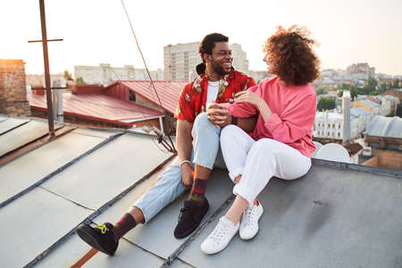Cheerful young couple relaxing on urban roofの写真素材