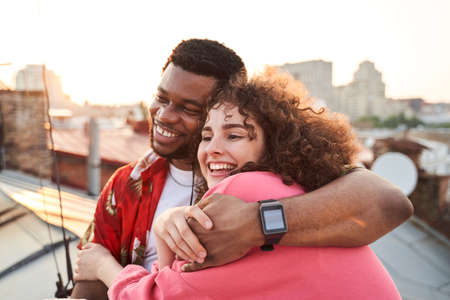 Cheerful attractive couple cuddling at summer sunsetの写真素材