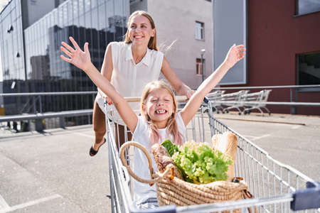 Cheerful female having fun with daughter during shoppingの写真素材