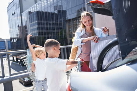 Happy young woman with kids after shopping