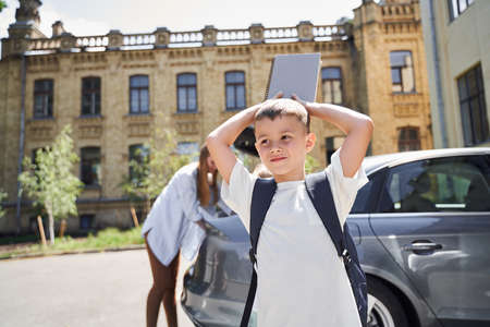 Smiling little boy with family near car