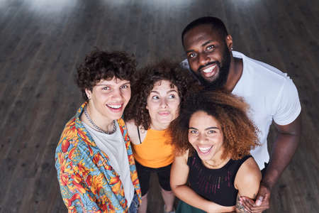 Happy young friends hugging together in studioの写真素材