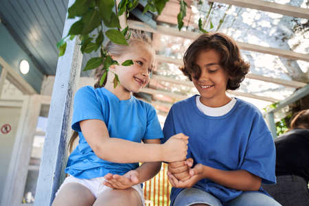 Cute joyful boy playing with sister outdoors
