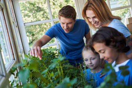 Happy family spending time together in orangeryの写真素材