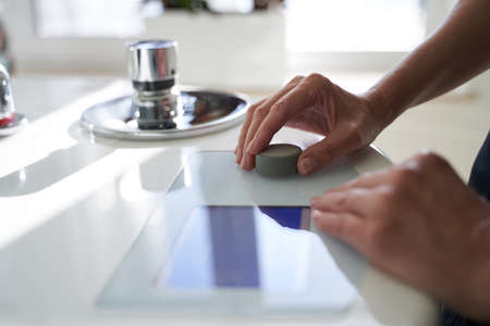 Hands of woman touching round control of the bathtub