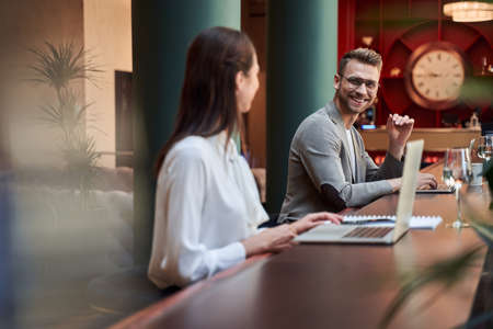 Friendly people at the bar counter with modern gadgets