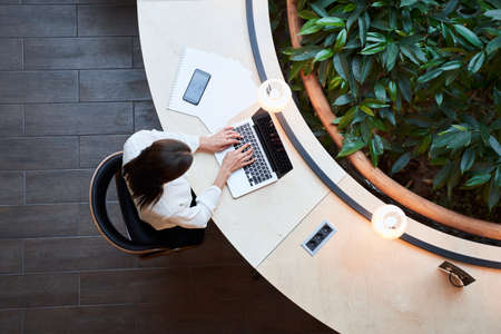 Young woman working on her laptop in a library