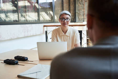 Woman in glasses sitting across table from a manの写真素材