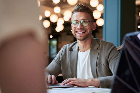 Enthusiastic smiling young businessman at his workplace