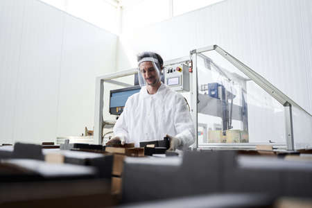 Pleased male worker examining the food packagingの写真素材