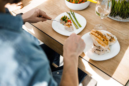Male cutting meat in a plate at the festive table