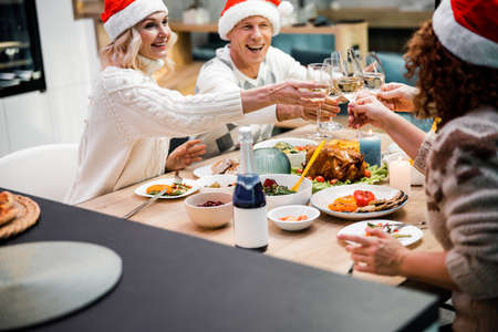 Smiling friends having festive dinner at homeの写真素材