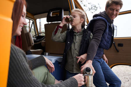 Family drinking hot tea at the nature