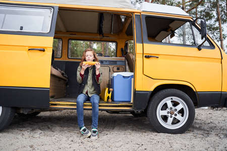 Girl eats corn with an appetiteの写真素材