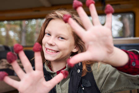 Girl with berries on her fingersの写真素材