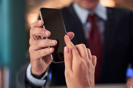 Close up shot hand touching smartphone