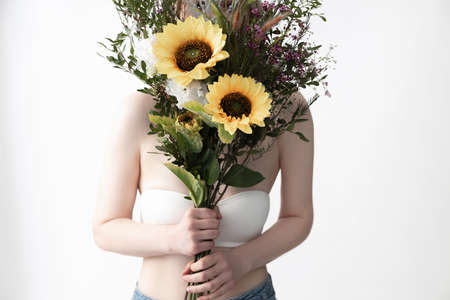Young woman in white bra holding beautiful bouquetの写真素材