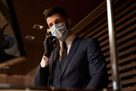 Calm attractive man talking on the phone at workの写真素材