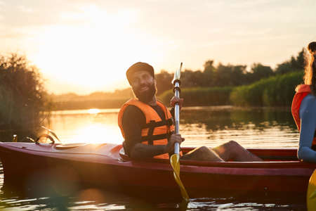 Waist up portrait of tattooed guy in kayak