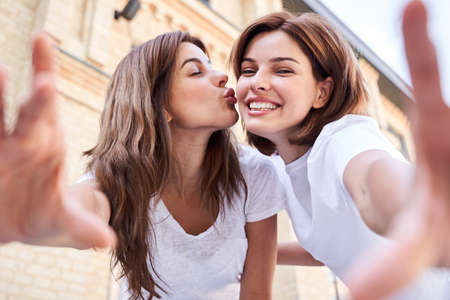 Girl kisses her friend to the cheekの写真素材