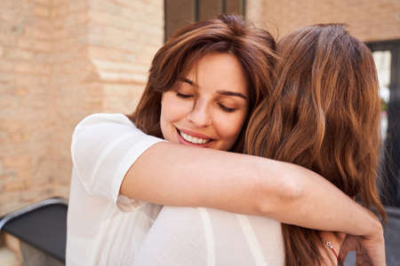 Lady hugs his sister carefullyの写真素材