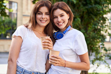 Girls holding cup of coffee at the park
