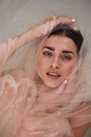 Woman laying under the transparent fabric