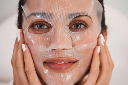 Woman applying mask on faceの写真素材