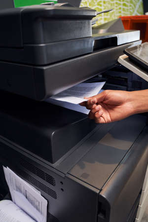 Man is placing a document on scannerの写真素材