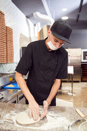 Pizzaiolo with prepearing dough for pizzaの写真素材